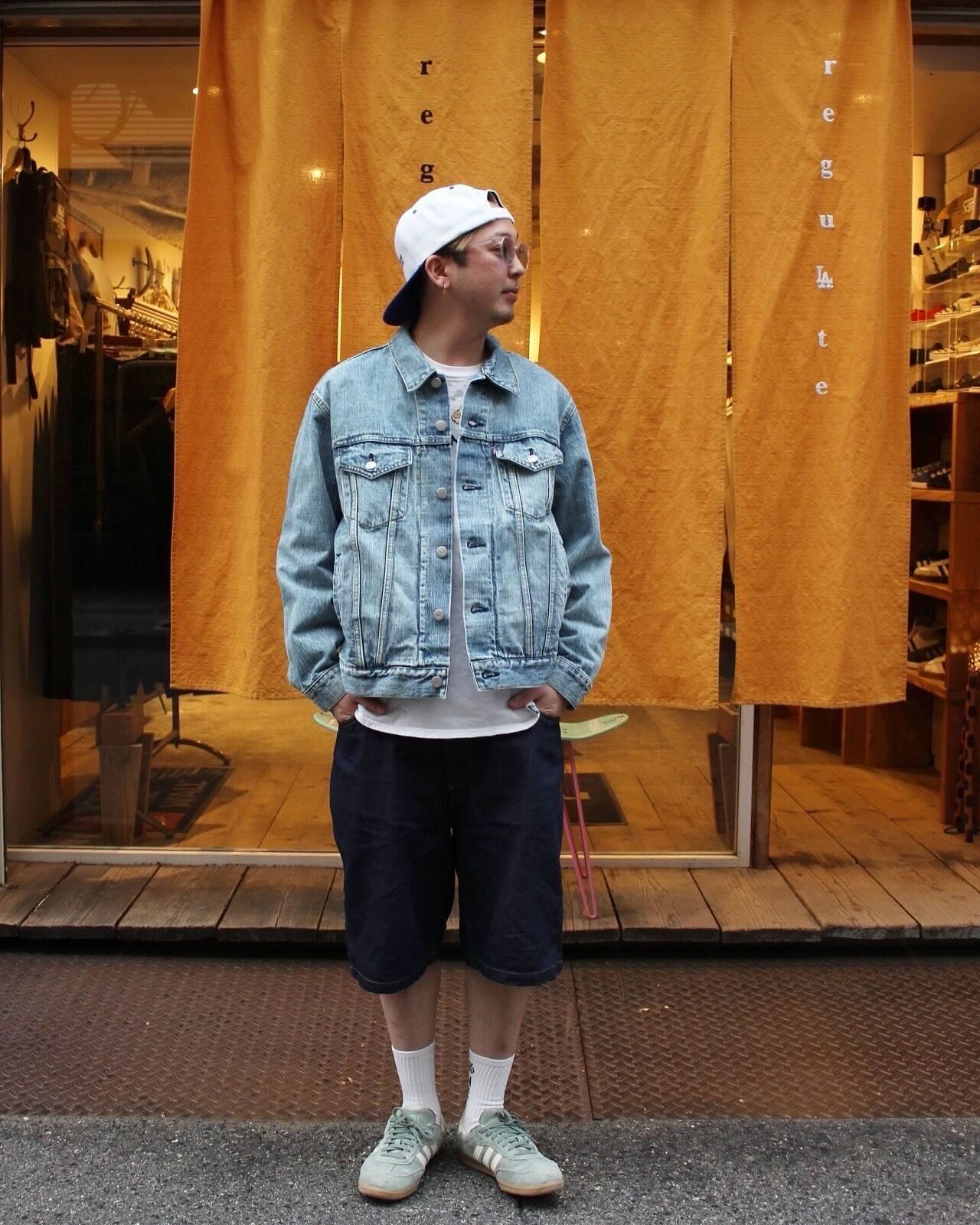 店内のオレンジののれんの前で